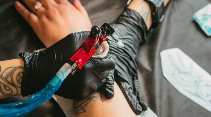 Tatuaż z grupą krwi w trakcie wykonywania przez tatuatora