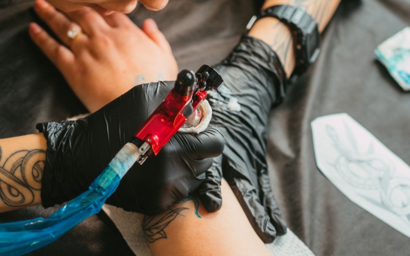Tatuaż z grupą krwi w trakcie wykonywania przez tatuatora