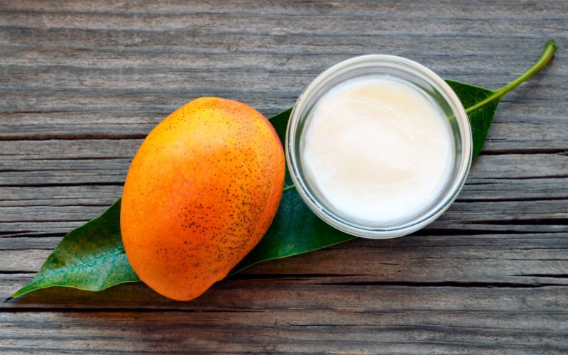 Masło mango do kosmetyków w towarzystwie owocu mango