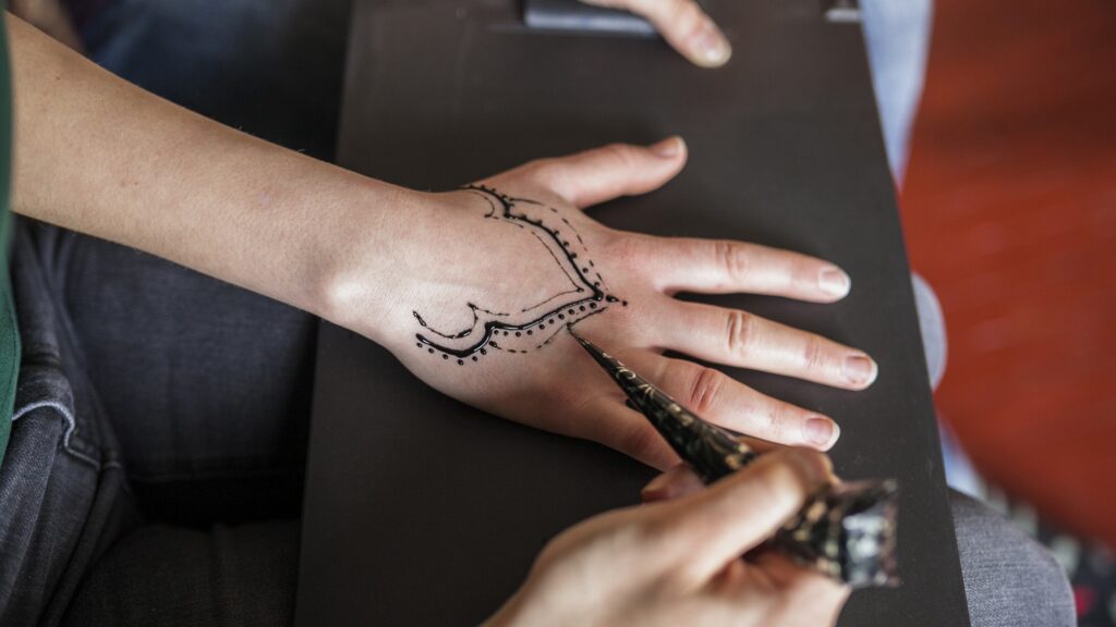Tatuowanie dłoni w studio tatuażu.